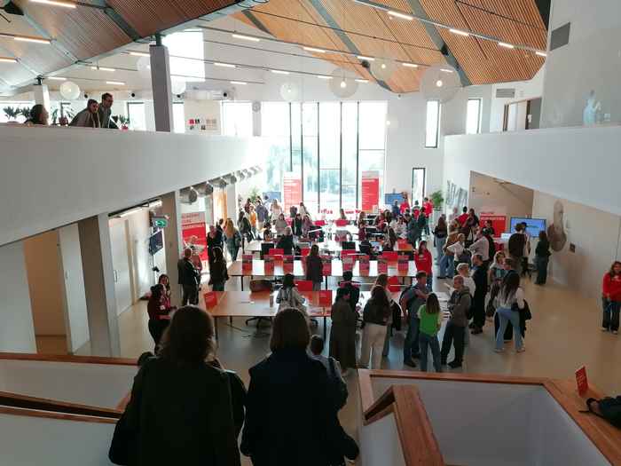 Two students walking down stairs to an information market AUC Open Day