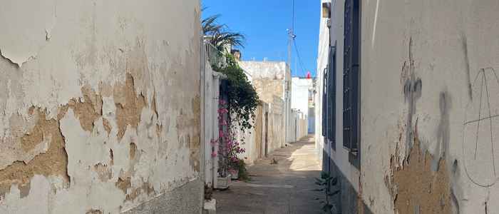 Walls of houses damaged as a result of rising damp, a street in Faro, Portugal.
